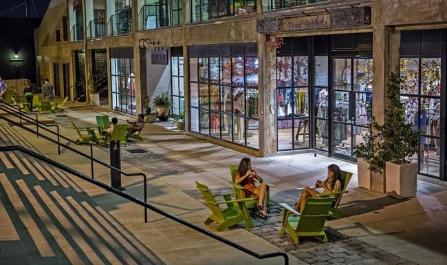 people sitting on chairs outside neighborhood shops
