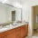 bathroom vanity with dual sinks next to walk-in closet